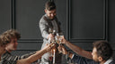 A man raising a toast to his friends at dinner.