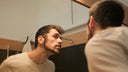 Man looking at his skin in the mirror.