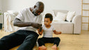 A dad and baby playing on the floor.