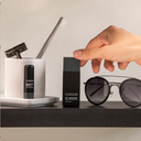 Cardon products on a shelf that includes sunglasses and a razor.