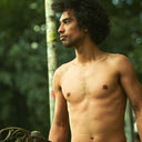 a shirtless guy with great skin holding a skateboard