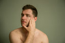 Man applying serum to his face.