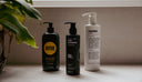 Three shampoos on a shelf.