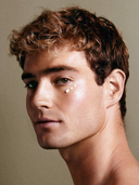 A handsome guy with some eye cream on under his eye.