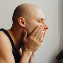 Man Applying aftershave to his face.