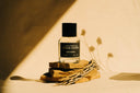 Perfume bottle labeled 'Ranger Station' on a wooden stand with a soft focus background