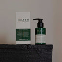Heath moisturiser bottle and packaging on a textured surface with a blurred background