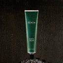 Green tube of Heath Shave Cream on a dark textured background
