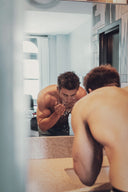 Man looking at himself in the mirror in a bathroom