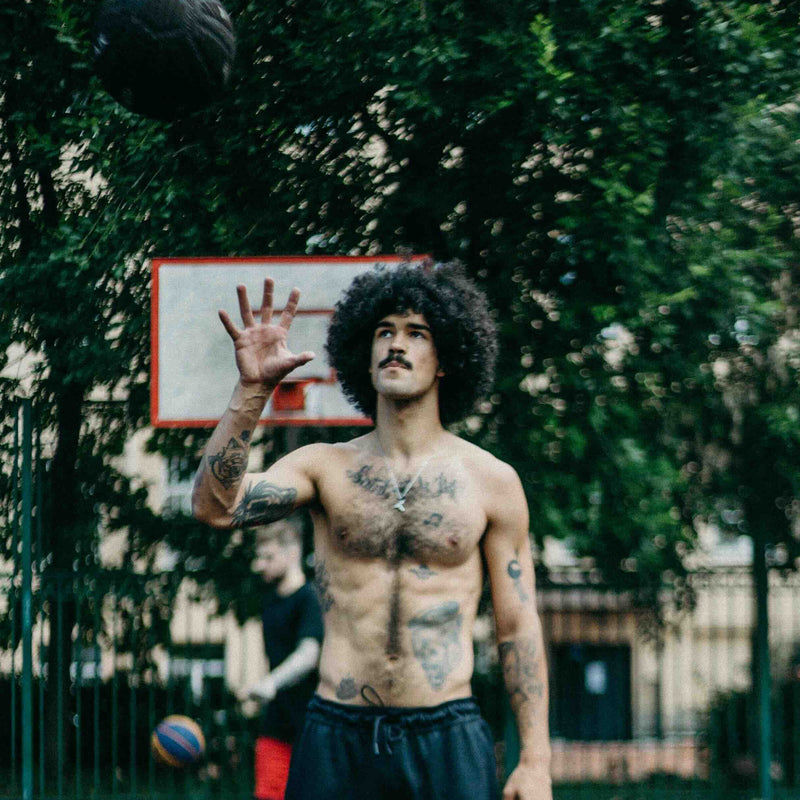A guy playing basketball outdoors