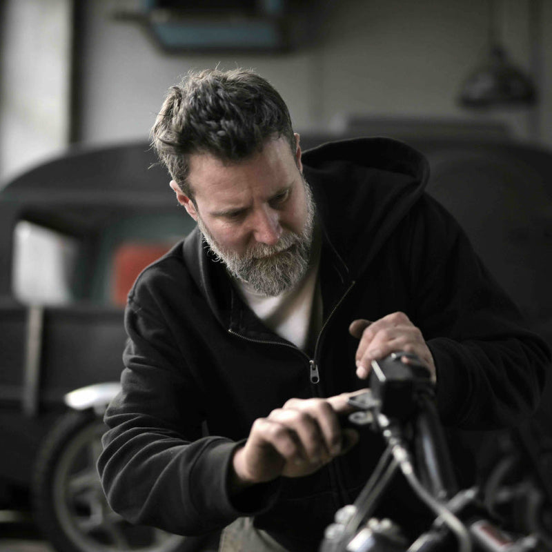 Man working on a motorcycle in a garage setting