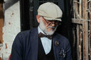 A dapper man sits reading a book.